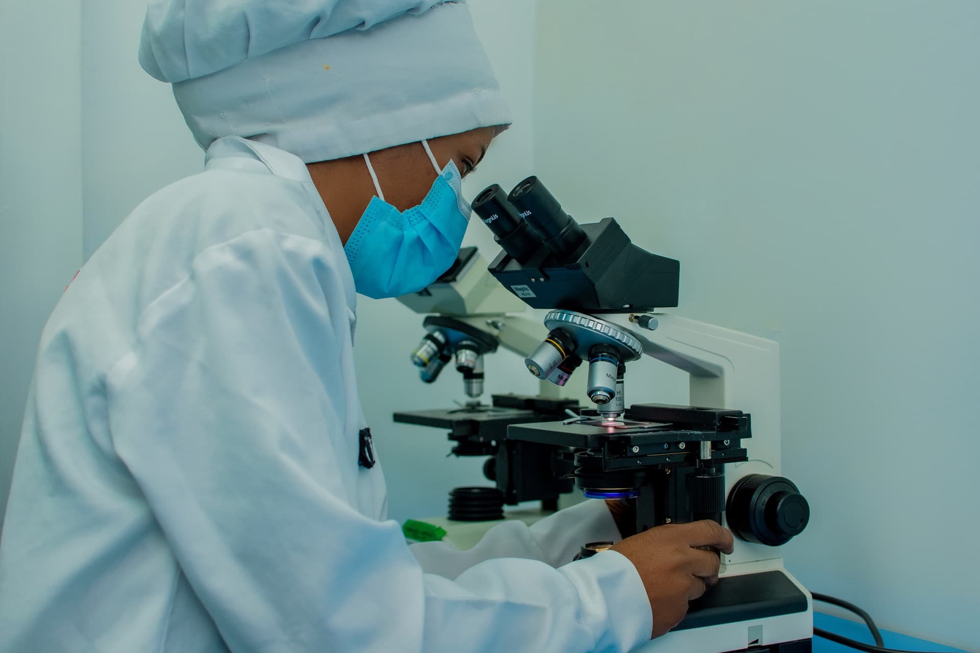 Laboratory analyst examining samples under a microscope
